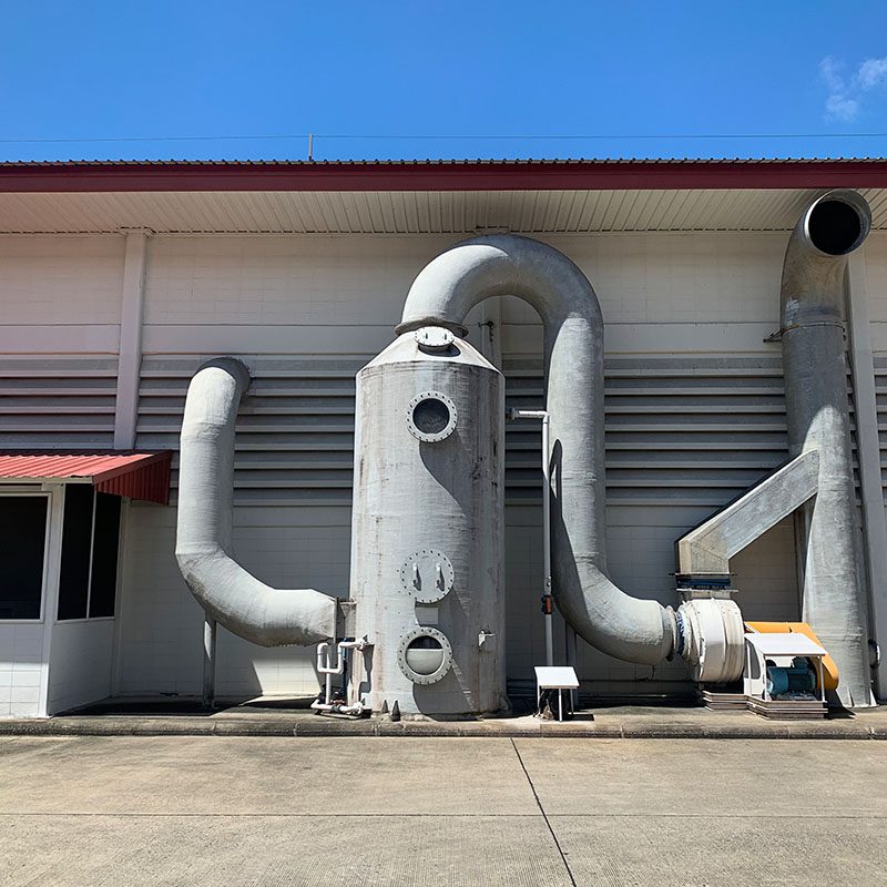 Industrial pipes against a building exterior.