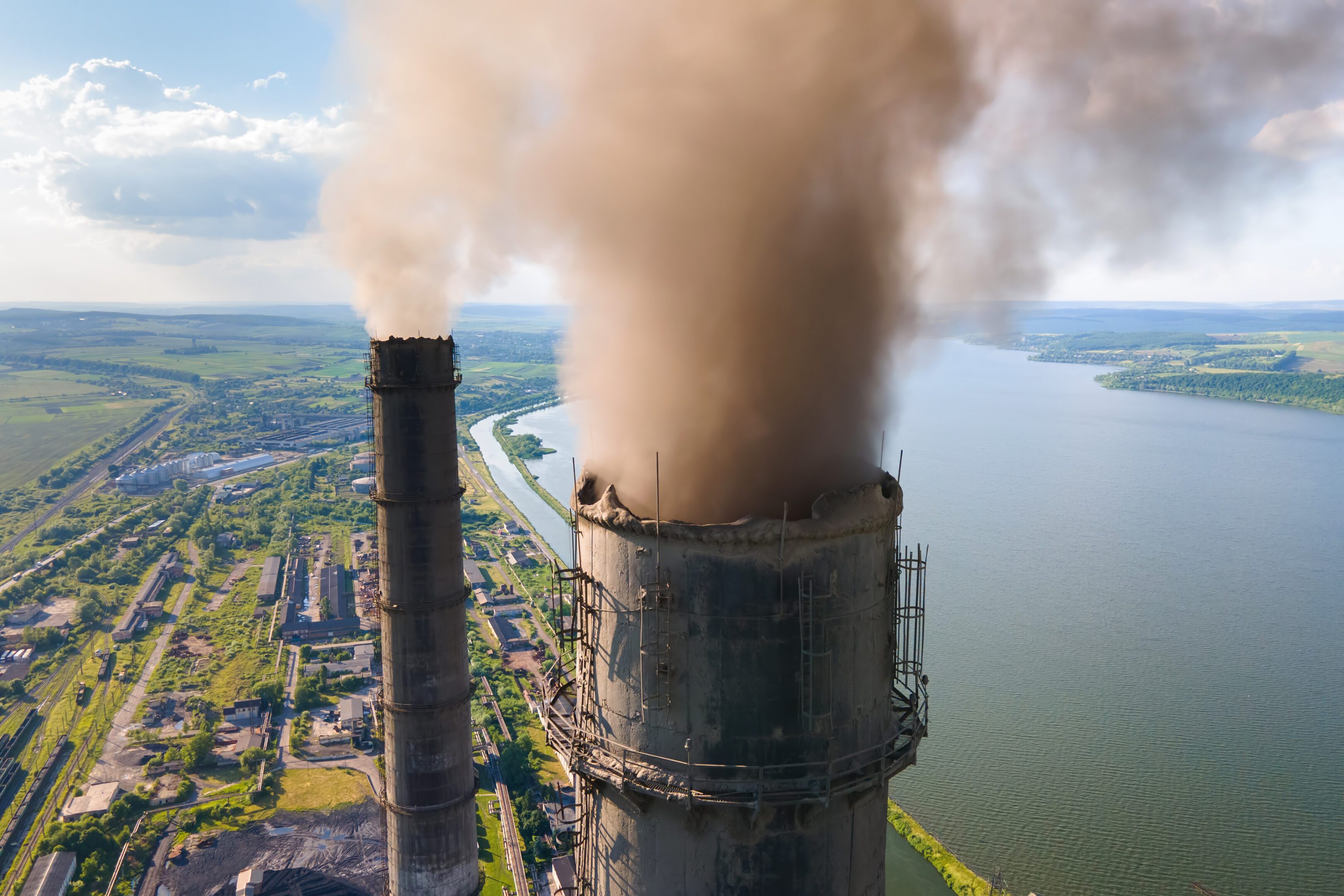 Aerial view of coal power plant high pipes with black smokestack polluting atmosphere. Electricity production with fossil fuel concept. Aerial view of coal power plant high pipes with black smokestack polluting atmosphere. Electricity production with fossil fuel concept.