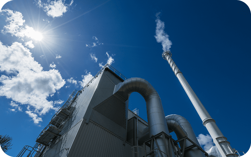 Industrial plant with pipes under blue sky.